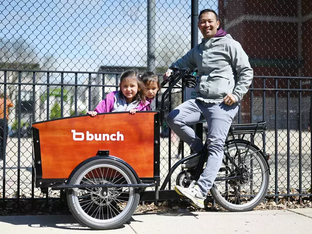 A man with his Bunch trike and two kids in the front