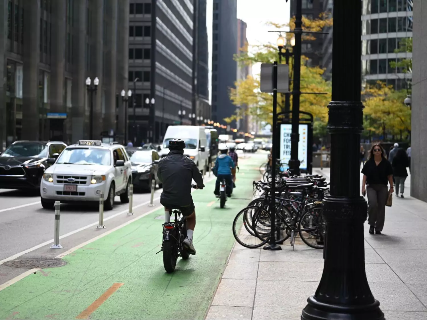 A two-way protected bike lane on Dearborn Street in downtown Chicago, with several folks riding