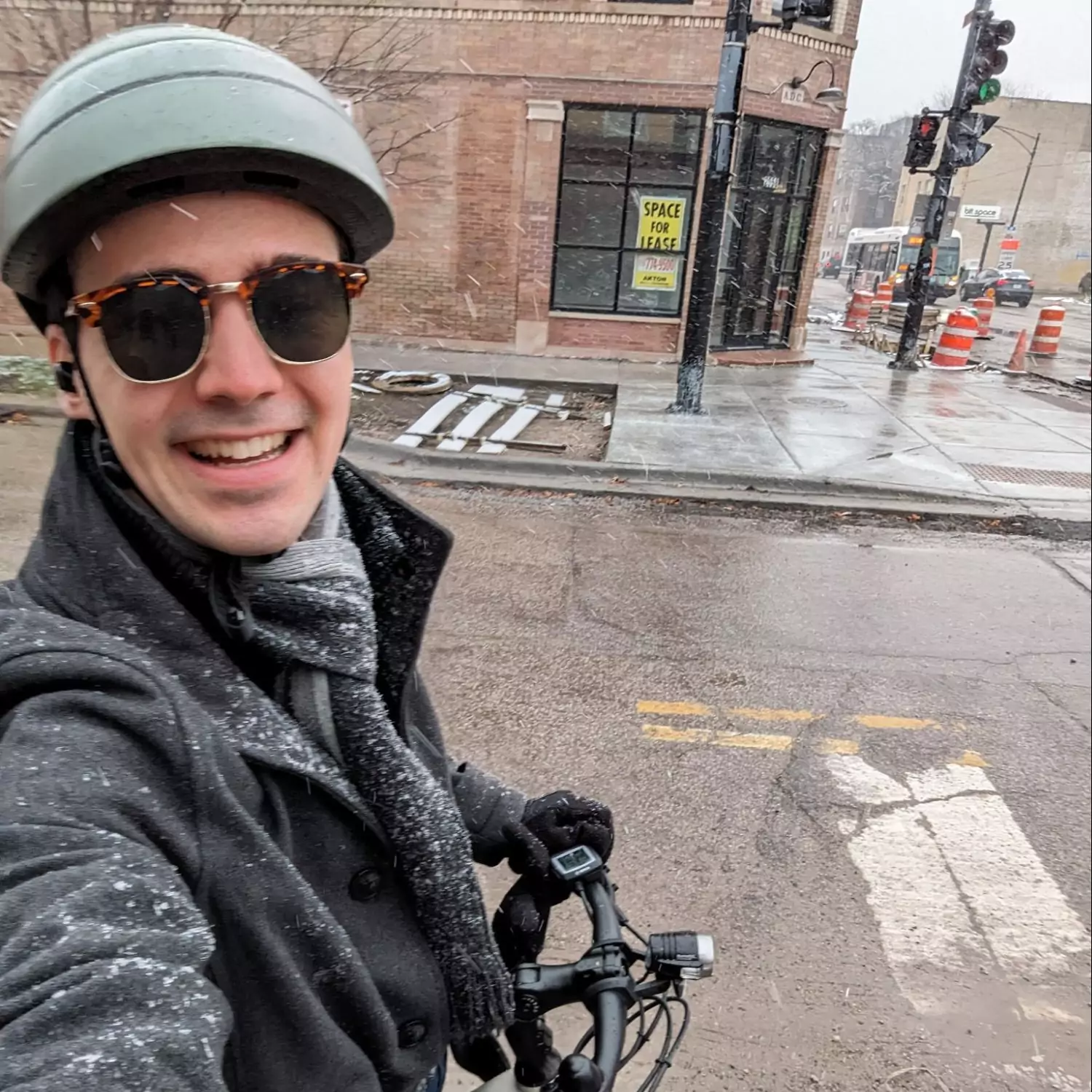 A selfie of Viktor with his bike, wearing a coat, and a scarf.