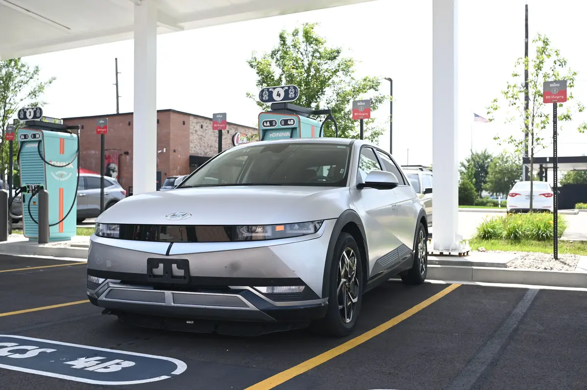 A matte grey 2023 Hyundai Ioniq 5 at an Ionna charging station on a sunny day